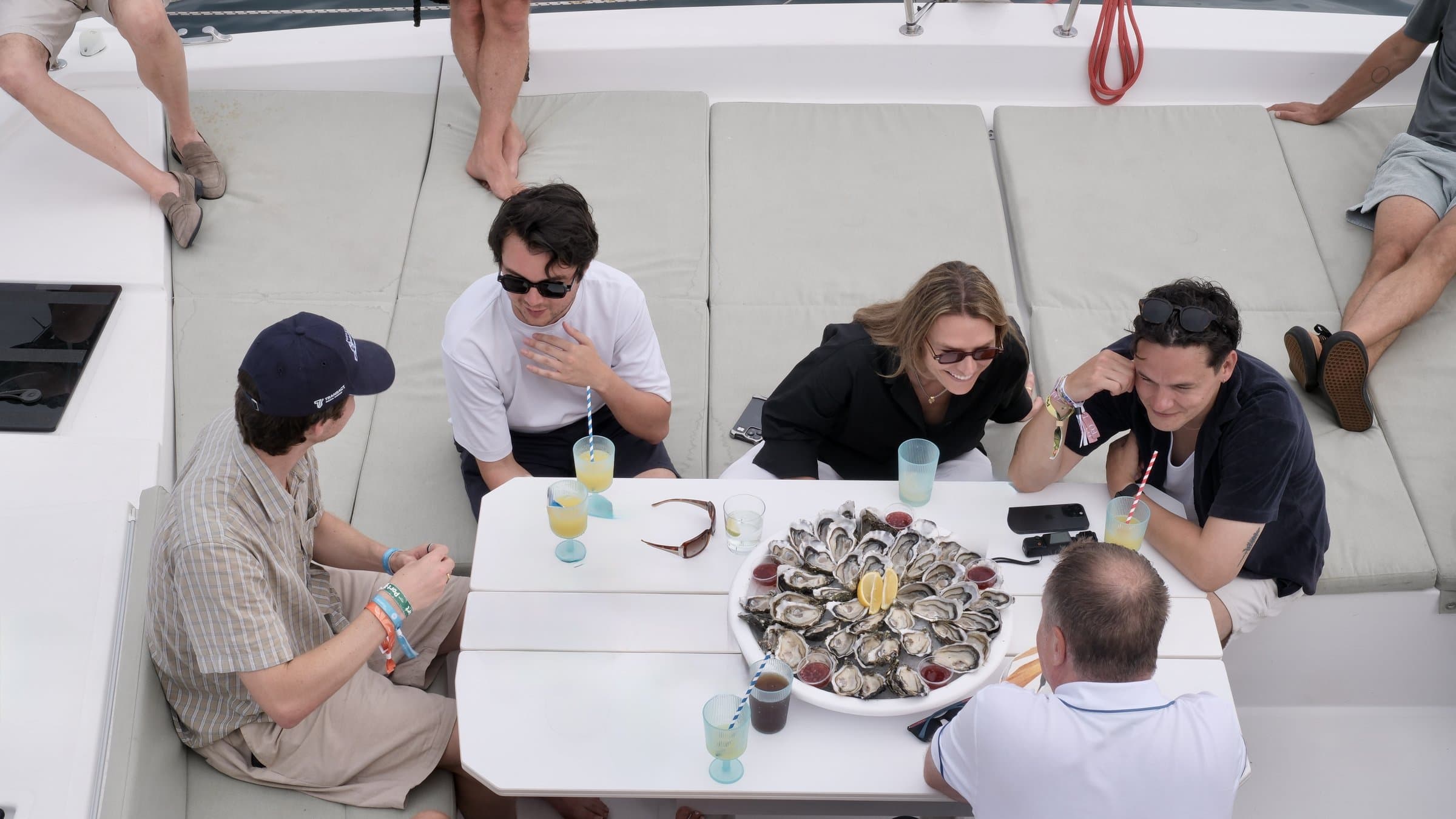 Team conversation around a catamaran cockpit table at anchor